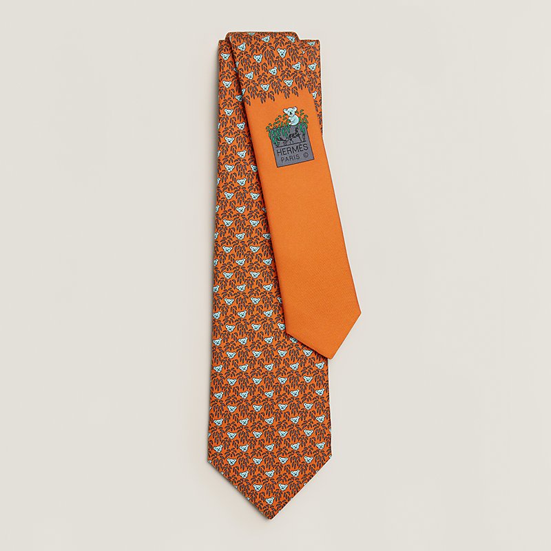 Cravate de la marque Hermès de couleur orange avec des motifs bleu et brun