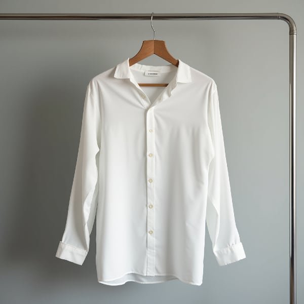 chemise blanche un peu transparente accrochée à un cintre