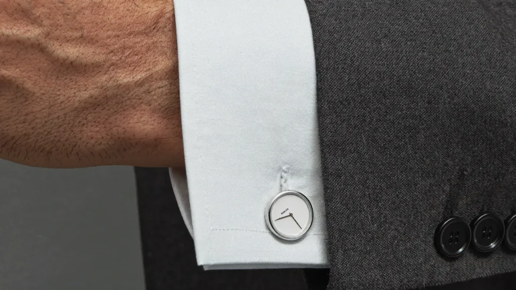 Poignet de chemise blanche avec bouton de manchette argent et nacre sous un costume
