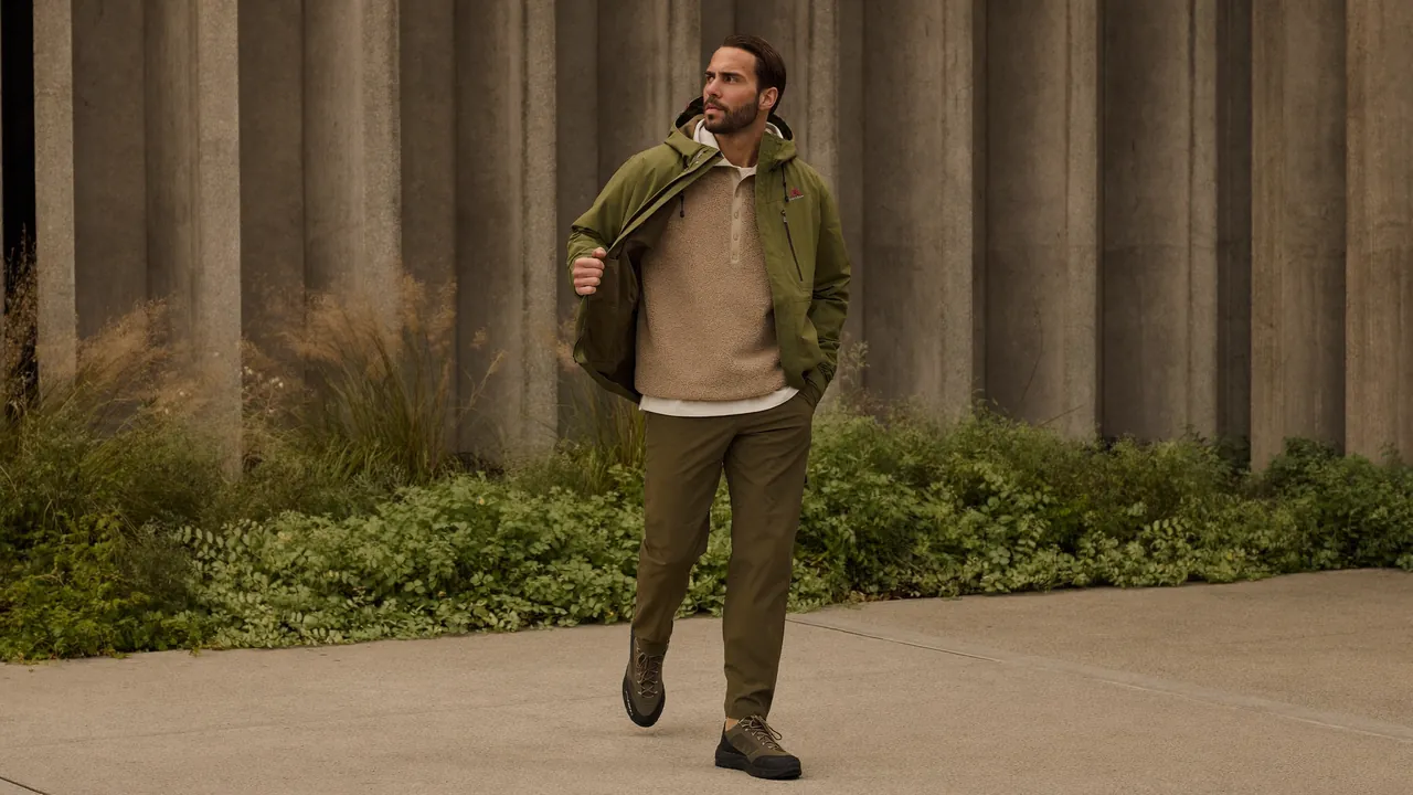 Homme en veste Gore-Tex olive et pantalon technique kaki dans un environnement urbain