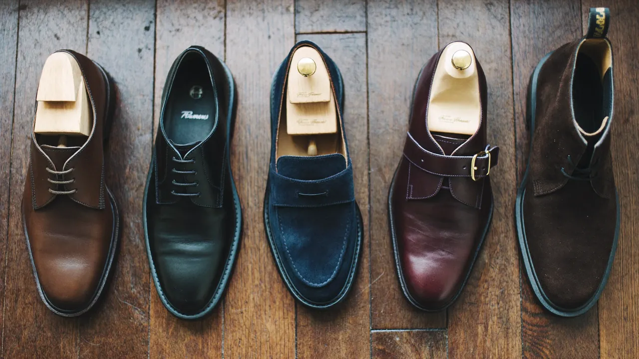 Cinq paires de chaussures en cuir homme alignées sur parquet