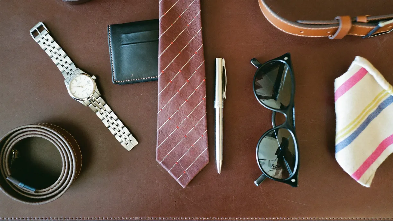 Plat lay d'accessoires homme essentiels sur sous-main en cuir