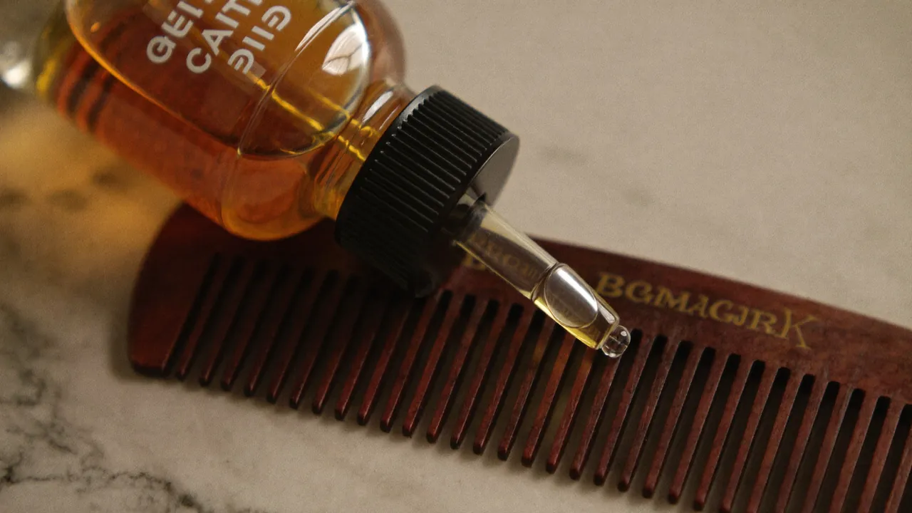 Flacon d'huile à barbe ambre avec peigne en bois sur marbre